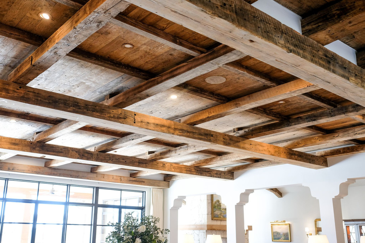 Reclaimed wood beam ceiling above arched plaster openings